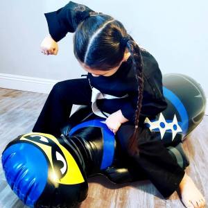 Girl in a Ninja costume and a Ninja Punching Bag
